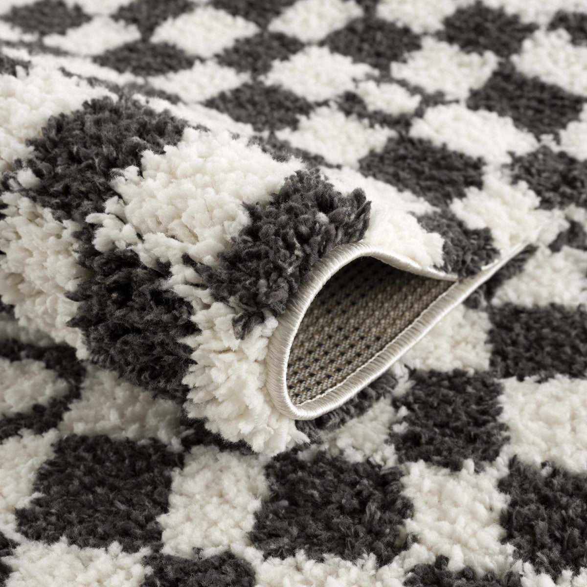 Black and white checkered shag rug by Boutique Rugs, showcasing a soft, textured surface with a modern geometric pattern.