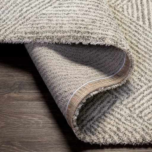 Folded Horsley Area Rug by Boutique Rugs, showcasing its textured pattern and soft fabric in neutral tones.