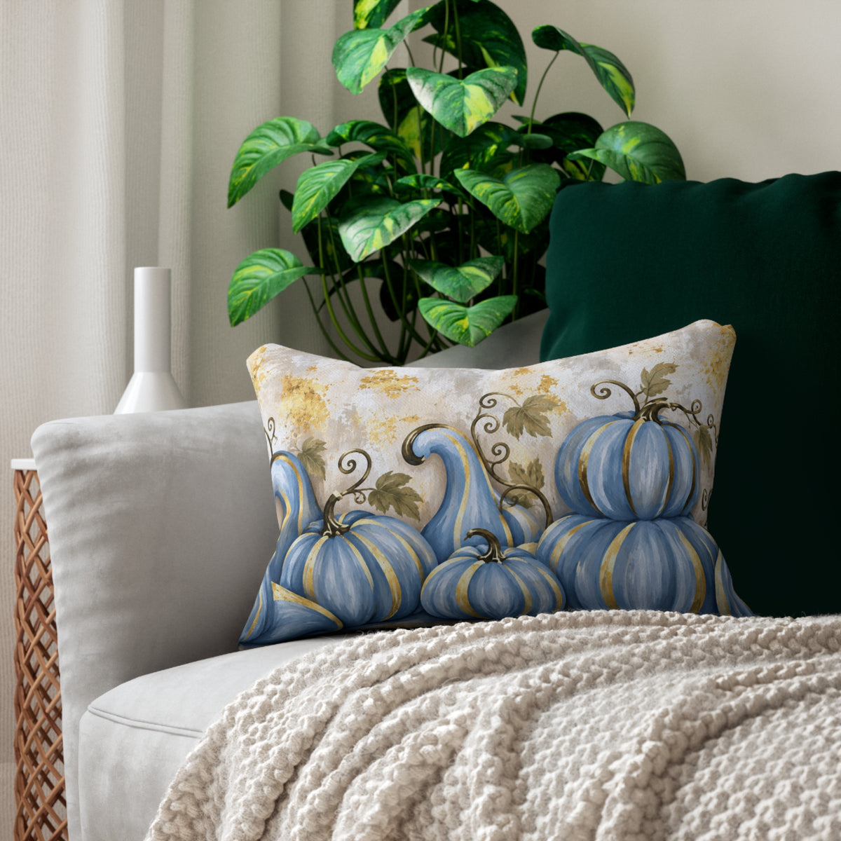 Blue pumpkin lumbar pillow by Kraft Paper Scissors with gold accents, elegant fall home decor throw pillow on a sofa.