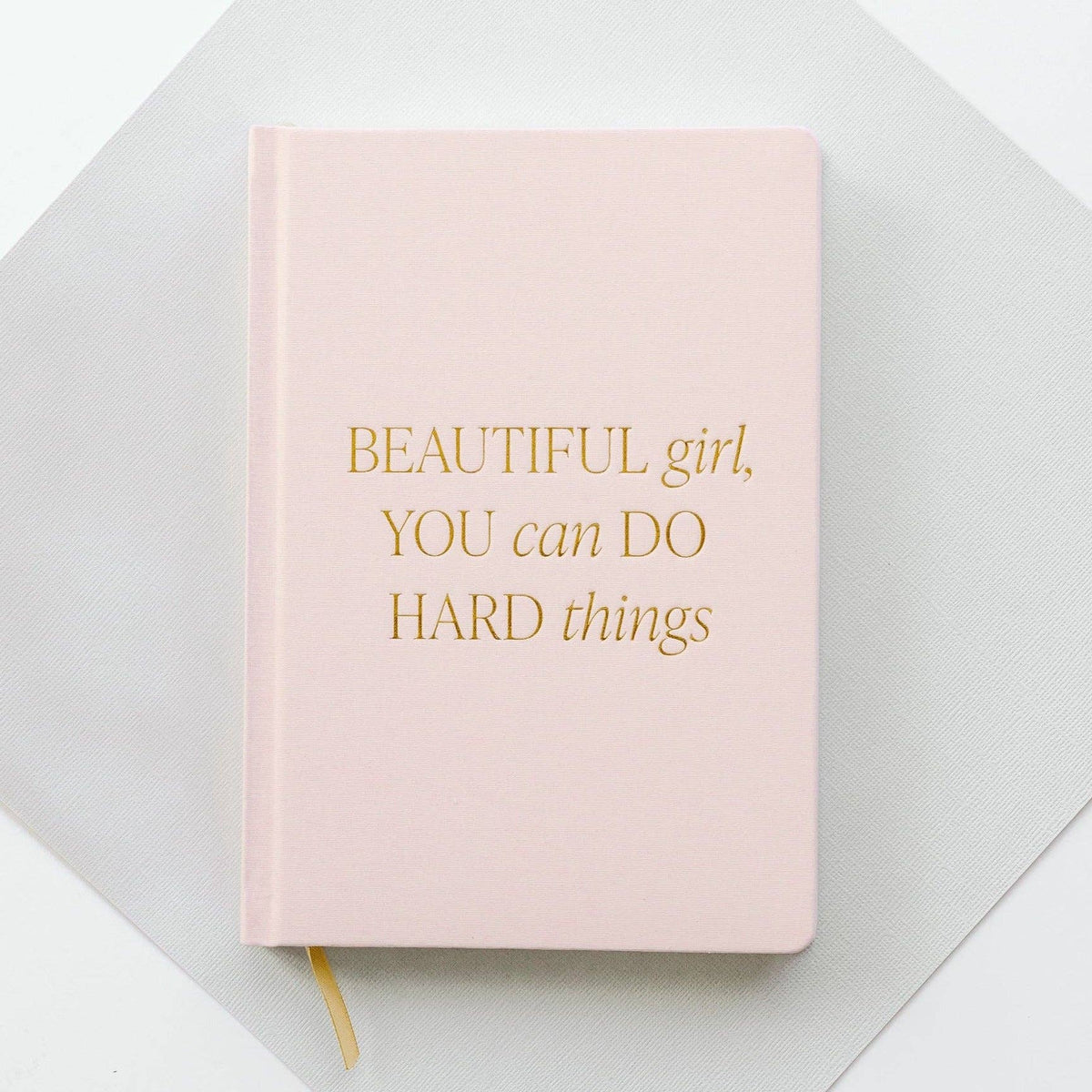 Pink fabric journal titled "Beautiful Girl, You Can Do Hard Things" by BlackbirdOak with kraft paper background and scissors.