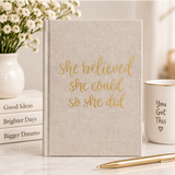 Tan fabric journal with kraft paper cover featuring the phrase "She Believed She Could So She Did" by BlackbirdOak.