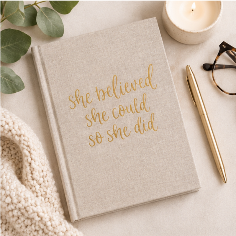 Tan fabric journal with kraft paper cover featuring the motivational phrase "She Believed She Could So She Did" by BlackbirdOak.