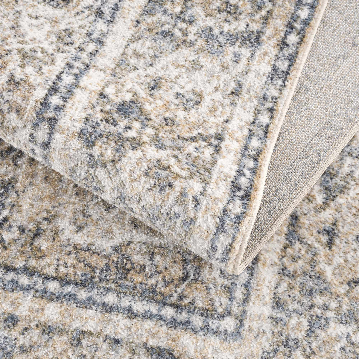 Colorful washable rug from Arias Boutique Rugs, shown folded with vibrant patterns and soft texture in a studio setting.