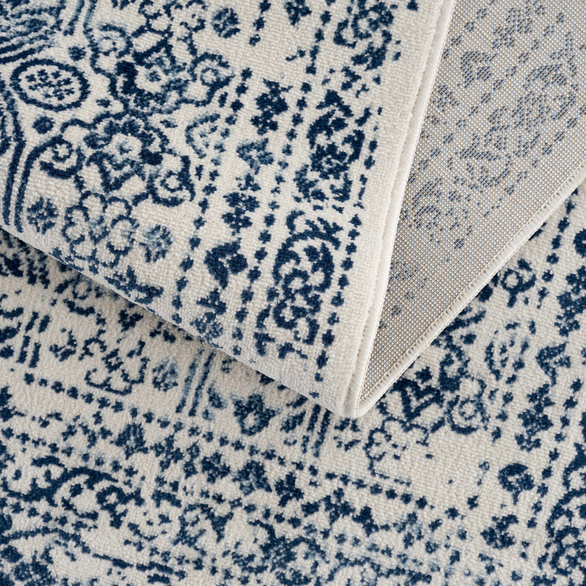 Hauteloom Michie Blue Area Rug with intricate patterns, showcasing soft, woven fabric in shades of blue and neutral tones.