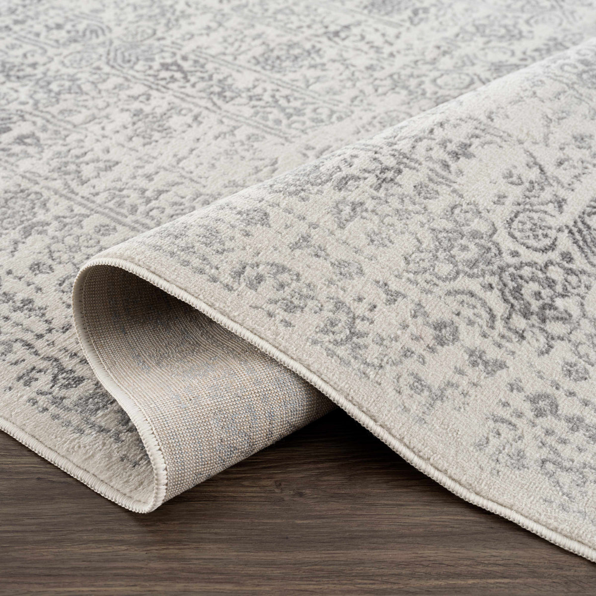 Hauteloom Michie area rug with intricate geometric patterns in neutral tones, displayed on a hardwood floor.